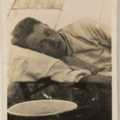 Photos of Walter Powell lying on a camp bed in a tent (1)